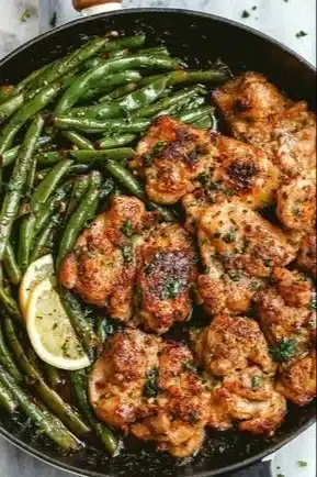 Lemon Garlic Butter Chicken Thighs garnished with herbs and lemon slices