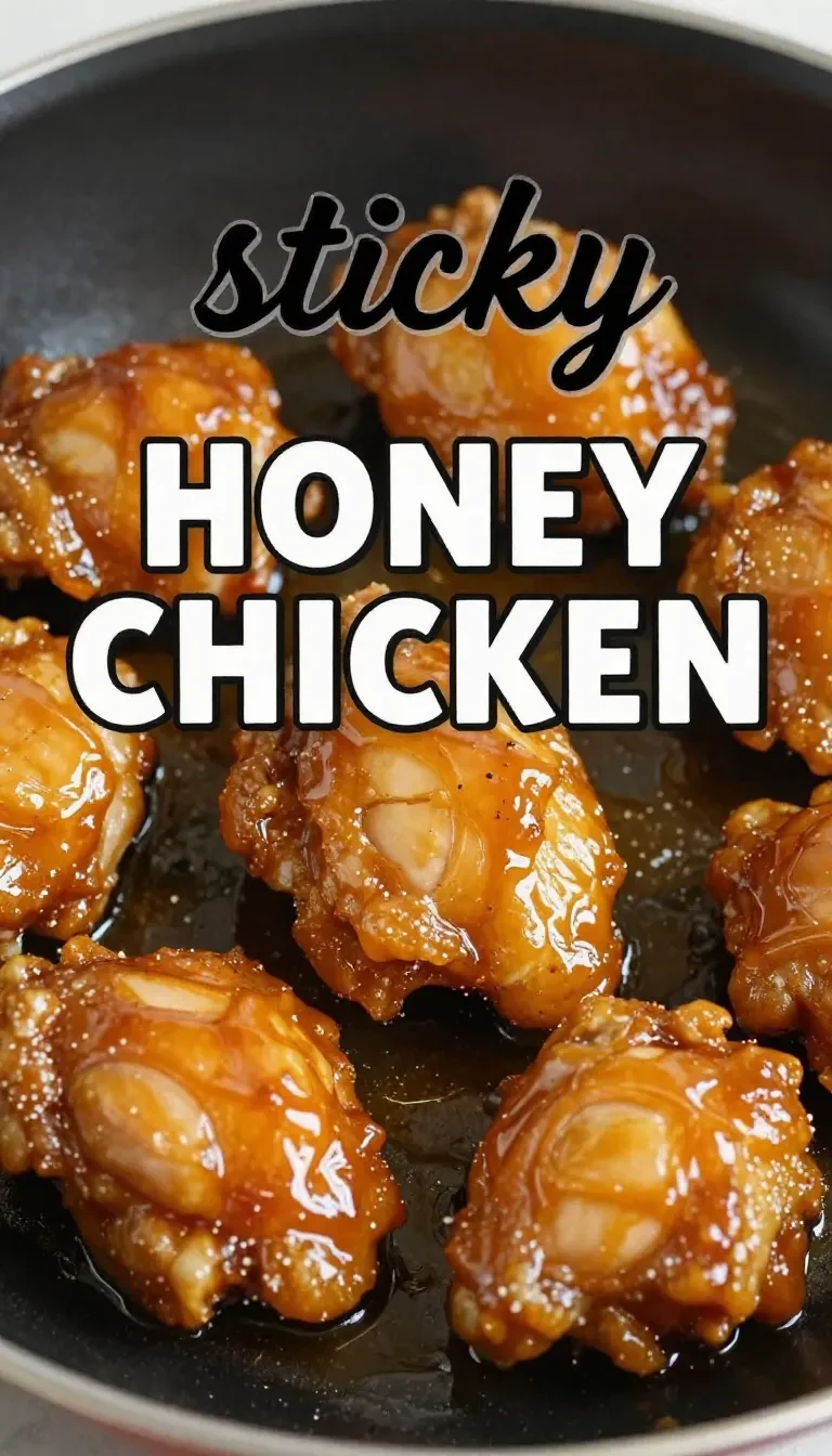 Close-up of sticky honey chicken garnished with sesame seeds and green onions on a white plate.